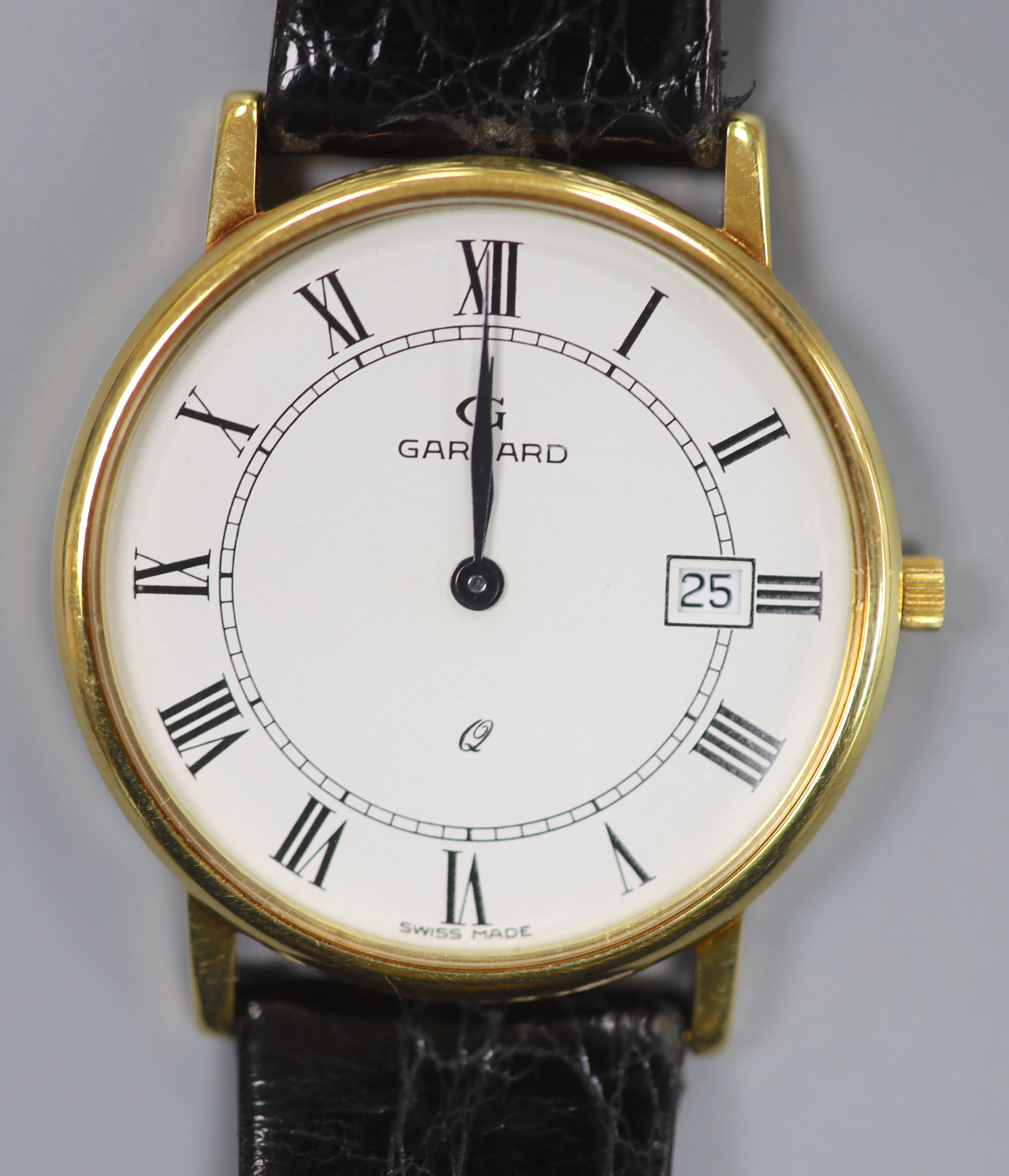 A gentlemans modern 18ct gold quartz dress wrist watch, retailed by Garrard, on a black leather strap, with Garrard box,